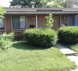 Country Club Apartments unit entry with landscaped shrubs