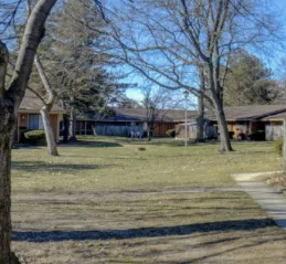 Country Club Apartments grounds with mature trees and open green space